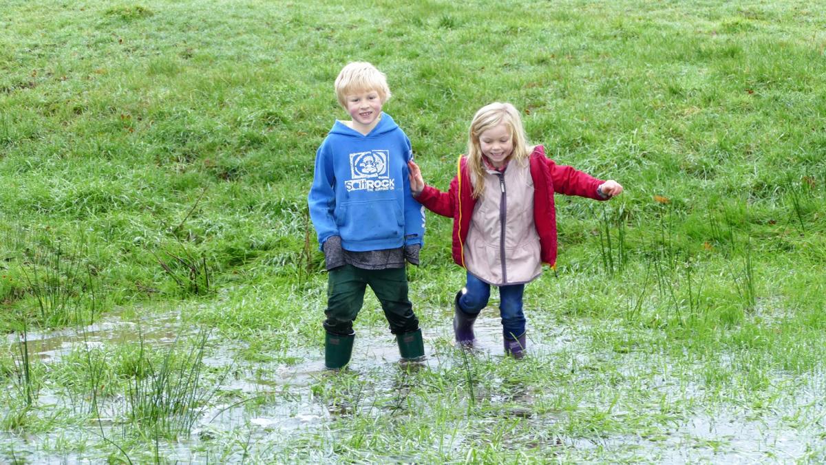 Kids in big field puddle